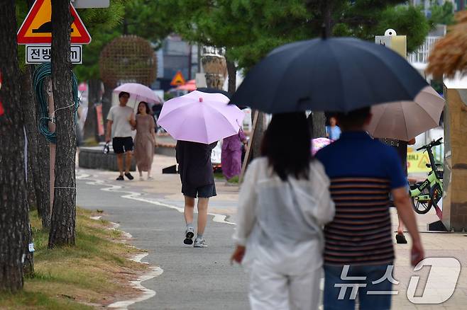 7일 경북 포항시 북구 영일대해수욕장에서 우산을 쓴 시민들과 관광객들이 해안도로를 따라 걸어가고 있다. 2025.9.7/뉴스1 ⓒ News1 최창호 기자