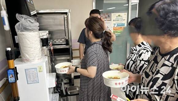 오산시하나울복지센터를 이용하는 중증장애인 보호자들이 컵라면에 물을 받고 있다. [사진=김장중기자]