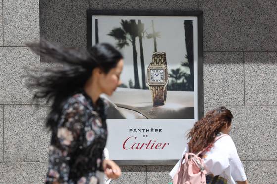 Pedestrians walk by a poster in Seoul advertising Cartier's watches on June 4. [YONHAP]