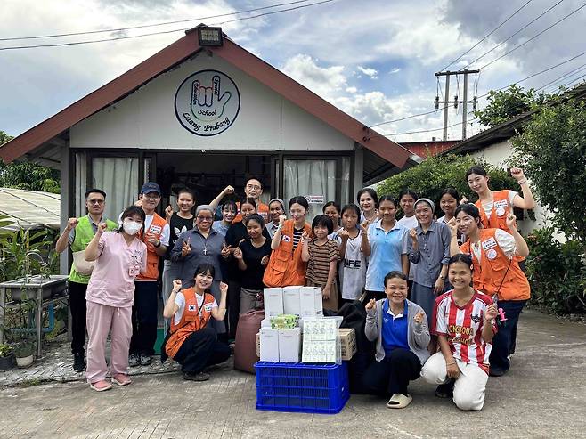 제주항공과 열린의사회 자원봉사자들이 라오스 루앙프라방에서 애경산업의 후원품을 주민들에게 전달하고 기념촬영을 하고 있다. [제주항공 제공]