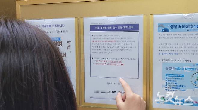 엘리베이터에 부착된 급수 중단 계획 안내문을 보고 있는 주민. 전영래 기자