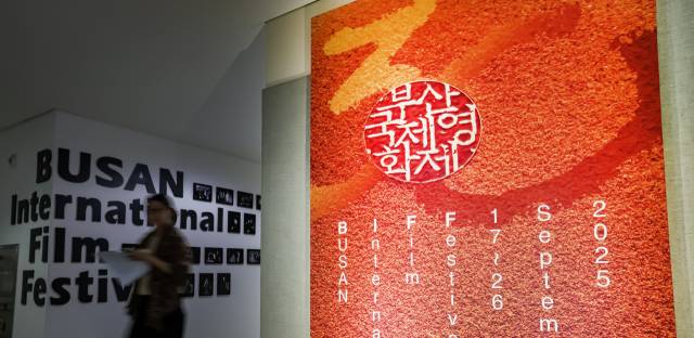 제30회 부산국제영화제 개막을 일주일여 앞둔 9일 부산 해운대구 영화의전당에 영화제 공식 포스터 앞으로 관계자가 지나가고 있다. 김종진 기자 kjj1761@