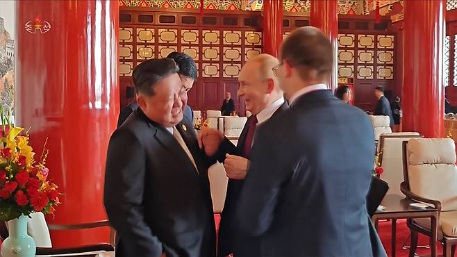 북한 조선중앙TV는 6일 김정은 국무위원장의 지난 2~4일 중국 방문을 담은 기록영화를 방영했다. 사진은 중앙TV가 공개한 김정은 위원장과 블라디미르 푸틴 러시아 대통령이 열병식 행사가 끝난후 만나서 대화하는 도중 파안대소하는 모습. /조선중앙TV 연합뉴스