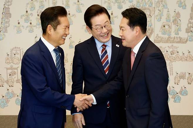 이재명 대통령이 8일 서울 용산 대통령실 청사에서 열린 여야 지도부 오찬 회동에서 정청래 더불어민주당 대표와 장동혁 국민의힘 대표의 악수 모습을 보며 밝게 웃고 있다. ⓒ뉴시스