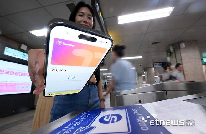 애플의 간편결제 서비스 애플페이가 지난 7월 22일부터 티머니 교통카드 지원을 시작했다. 서울시내 한 지하철 개찰구에서 시민이 애플페이 티머니 교통카드를 태그해 지하철을 이용하고 있다. 김민수기자 mskim@etnews.com