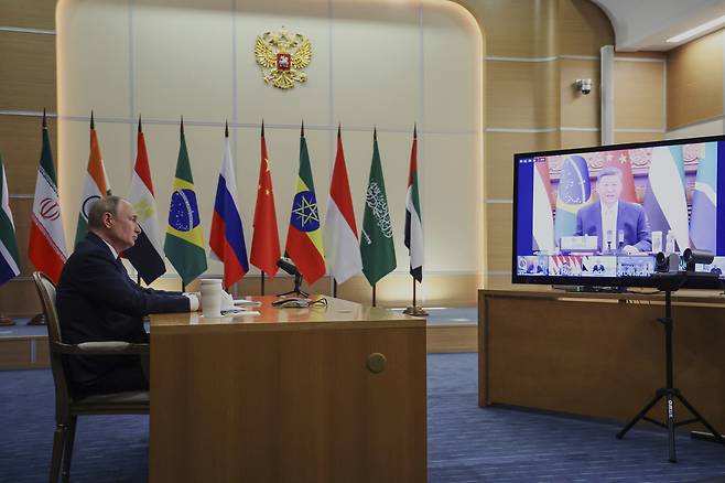 블라디미르 푸틴 러시아 대통령이 8일(현지시간) 브라질 리우데자네이루에서 열린 브릭스 정상 화상회의에 참석하고 있다. 화면에는 시진핑 중국 국가주석이 발언하고 있다. [AP]