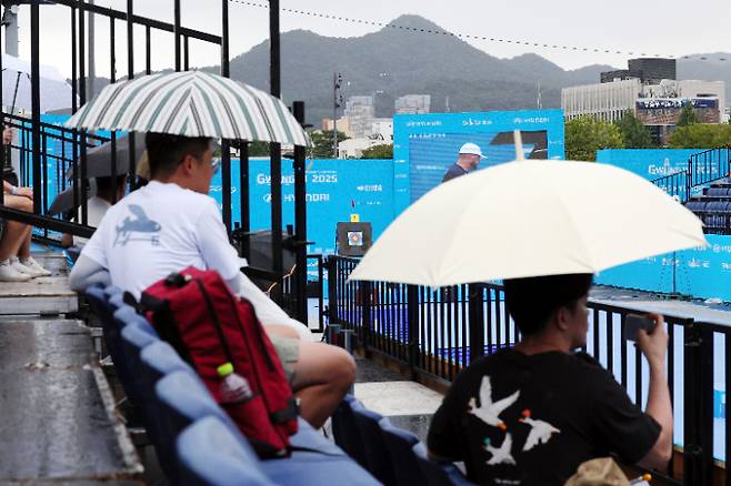 8일 오전 광주 동구 5·18민주광장에서 열린 2025 세계양궁선수권대회에서 관람객들이 우산을 쓰고 경기를 보고 있다. 연합뉴스