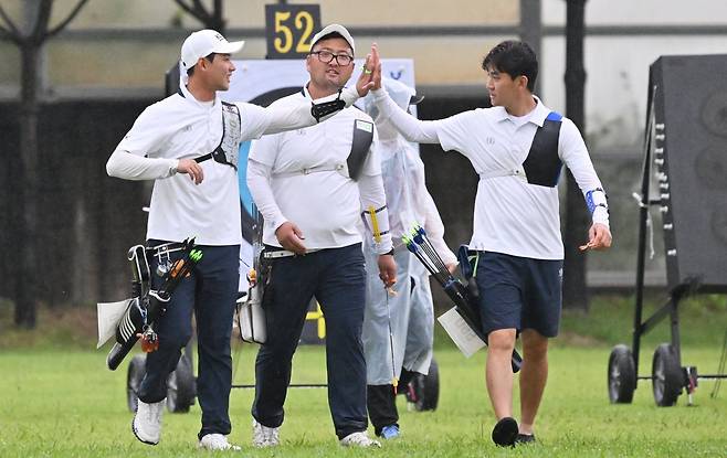 양궁 리커브 남자대표팀 이우석, 김우진, 김제덕(왼쪽부터)이 9일 광주국제양궁장에서 열린 양궁세계선수권대회 단체전 4강전에서 일본을 꺾고 결승전 진출을 확정한 뒤 환하게 웃으며 서로를 격려하고 있다. 광주|뉴시스