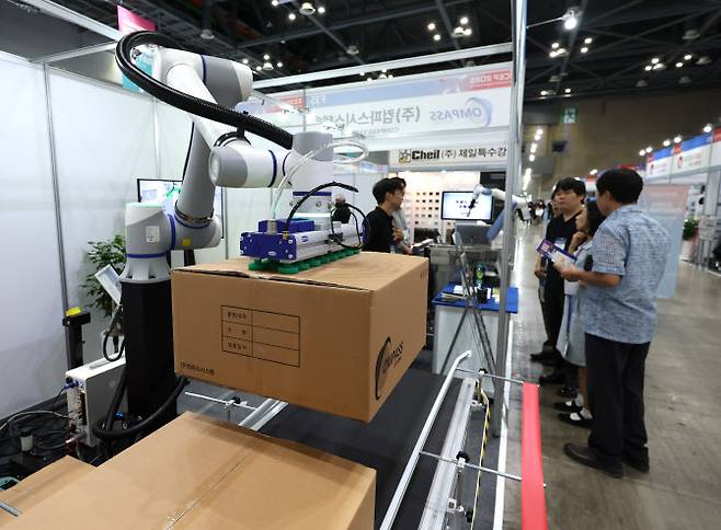 10~12일 경기도 고양시 킨텍스에서 열리는 제1회 대한민국 산업단지 수출박람회를 찾은 관람객들이 팔레타이징 로봇에 대한 설명을 듣고 있다. (사진=뉴시스)