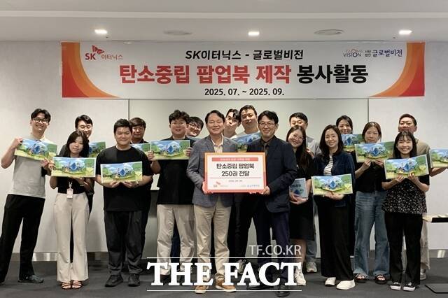 김해중 SK이터닉스 대표이사(오른쪽)와 차정훈 사단법인 글로벌비전 국장을 비롯한 SK이터닉스 임직원들이 탄소중립 팝업북 전달식에 참여하고 있다. /SK이터닉스