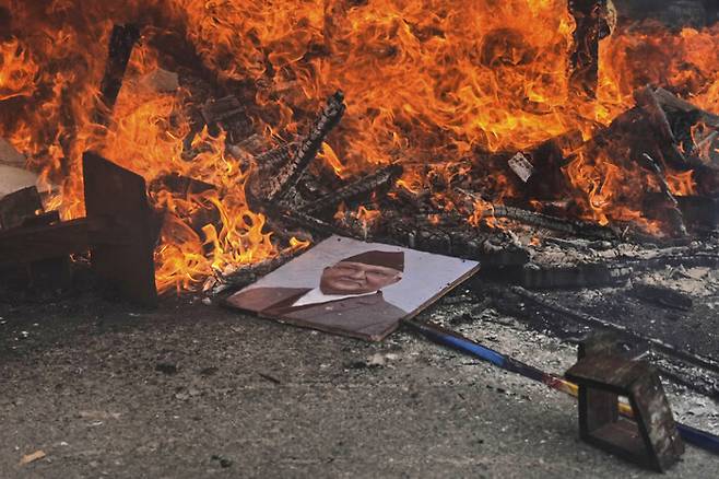 9일(현지시각) 반정부 시위 도중 시위대가 샤르마 올리 전 총리의 사진을 불태우고 있다. AP 연합뉴스