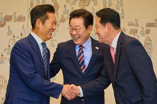 이재명 대통령이 8일 서울 용산 대통령실 청사에서 열린 여야 지도부 오찬 회동에서 정청래 더불어민주당 대표, 장동혁 국민의힘 대표가 악수하는 것을 보고 미소를 짓고 있다. 뉴스1