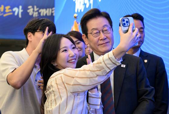 President Lee Jae Myung takes a selfie with a visitor at the National Growth Fund report session at Mapo District, western Seoul, on Sept. 10. [JOINT PRESS CORPS]