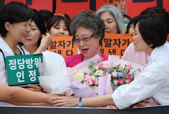 성폭행하려던 남성의 혀를 깨물어 중상해 혐의로 기소돼 유죄 판결을 받았던 최말자씨가 10일 부산지법에서 열린 재심 선고 공판을 마친 뒤 꽃다발을 받고 있다. 최씨는 61년 만에 열린 재심에서 무죄를 선고받았다. 연합