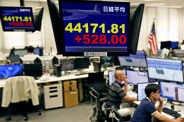 일본 도쿄의 한 외환 거래 업체 직원들이 9일 일본 닛케이225 평균주가를 보여주는 전광판 아래에 업무 중이다. 교도통신연합뉴스