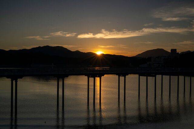 오목한 만을 가로지르는 해지개다리 너머로 해가 지고 있다. 노을이 하늘과 바다를 온통 붉게 물들이고 있다.