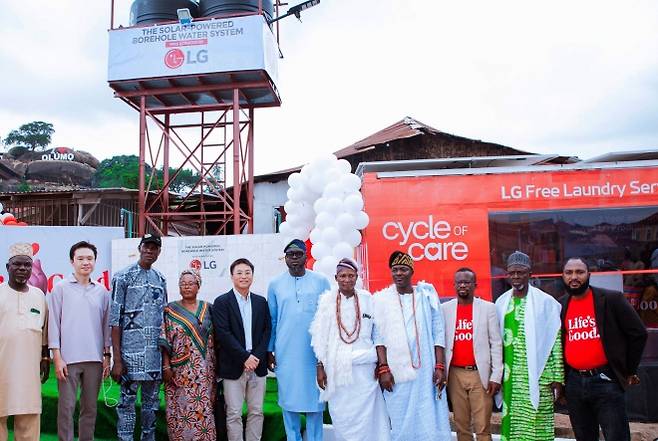 LG전자가 나이지리아 아베오쿠타시에 태양광만으로 24시간 깨끗한 물을 공급하는 식수 시설과 이동식 무료 세탁방을 마련했다고 11일 밝혔다. 사진은 아베오쿠타시 관계자와 LG전자 관계자들이 새로 조성된 시설 앞에서 기념촬영을 하고 있는 모습. LG전자 제공