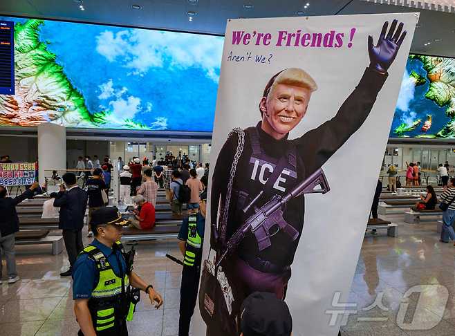 미국 조지아주 포크스턴 이민세관단속국(ICE) 구금 시설에서 체포·구금됐다 풀려난 한국인 316명이 탑승한 전세기가 12일 인천국제공항 2터미널에 도착한 가운데, 이제석 이제석광고연구소 대표가 공항 입국장에서 트럼프 미국 대통령 얼굴이 담긴 플래카드 퍼포먼스를 펼치고 있다.(공동취재) 2025.9.12/뉴스1 ⓒ News1 박지혜 기자