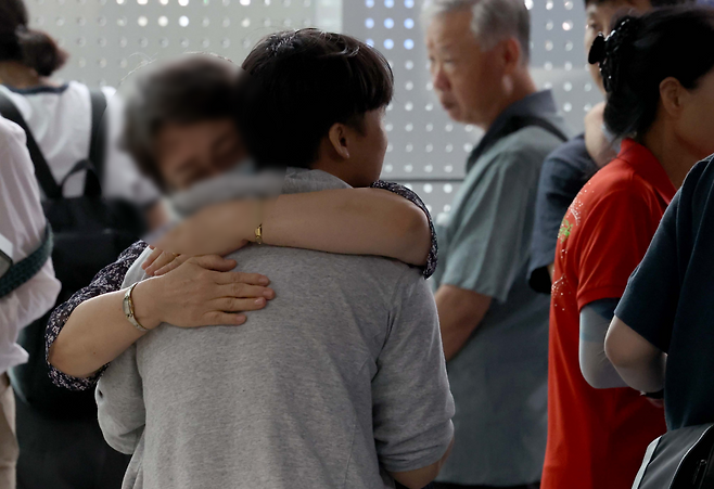 A South Korean national who returned home after being detained in the US greets his family at the Incheon International Airport, Friday. (Yonhap)
