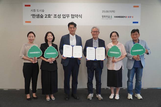 한샘과 평화의숲의 업무협약식에서 정광현(가운데 좌측) 한샘 경영지원본부장과 김재현(가운데 우측) 평화의숲 대표와&nbsp; 참석자들이 기념 촬영을 하고 있다. 한샘 제공