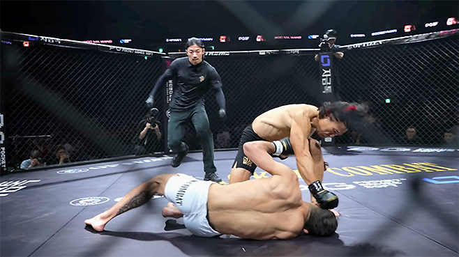 종합격투기 빅리그 ONE Championship 4전 파이터 ‘우마왕’ 우성훈이 2025년 8월 인천광역시 영종국제도시 인스파이어 아레나 블랙컴뱃 15 플라이급 경기에서 라이트훅으로 ‘부기맨’ 한제우 두스산투스를 다운시킨 데 이어 후속 공격을 하고 있다. 사진=이데아 파라곤