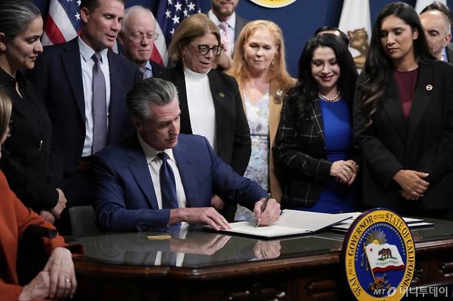 [새크라멘토=AP/뉴시스] 개빈 뉴섬 캘리포니아 주지사가 8월 21일(현지 시간) 새크라멘토 주지사실에서 주 의회를 통과한 선거구 재조정안과 특별 선거에 관한 법안에 서명하고 있다. 2025.08.22. /사진=권성근