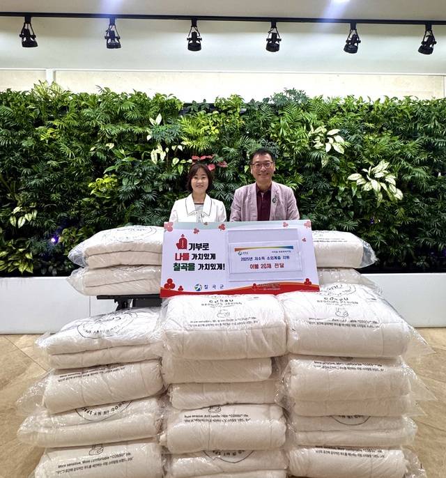 박정규(오른쪽) 석적읍장이 '이름 없는 천사'거 기탁한 이불을 앞에두고 기념사진을 찍고 있다. 칠곡군 제공