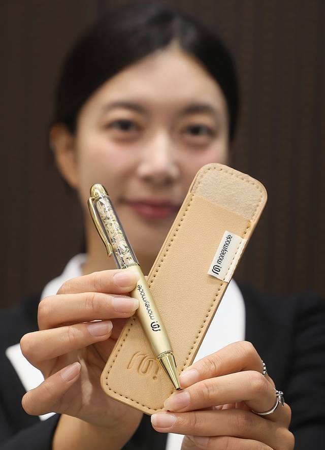 한국조폐공사 화폐제품판매관에서 모델이 ‘황금볼펜 에디션’을 소개하고 있다. [조폐공사 제공]