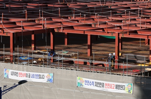 부산 수영구의 한 공사현장에 작업자들의 안전수칙 준수를 내용으로 하는 펼침막이 내걸려 있다. [연합뉴스 제공]