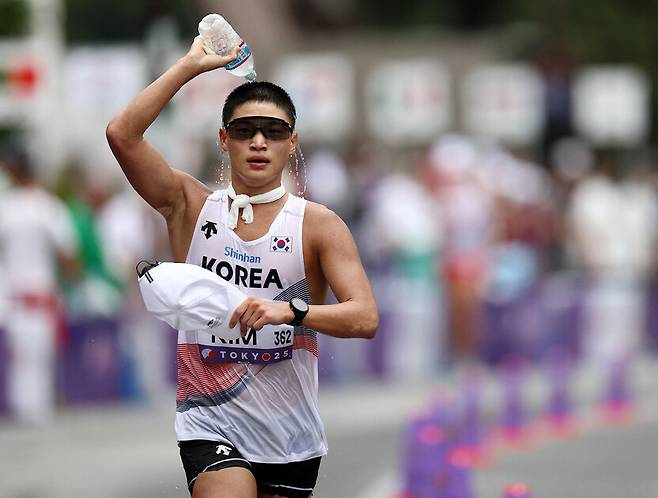 김민규가 13일(한국시각) 일본 도쿄 국립경기장에서 열린 2025 도쿄세계육상선수권 남자 35㎞ 경보에 출전해 물을 머리에 뿌리고 있다. 도쿄/로이터 연합뉴스