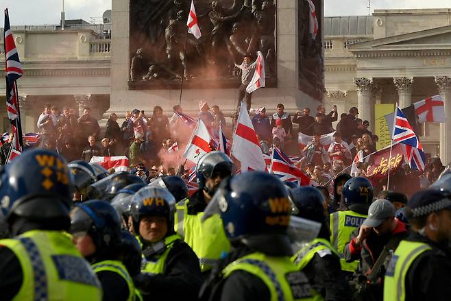 영국 반이민 운동가 스티븐 억슬리-레넌(일명 토미 로빈슨)이 13일(현지시간) 주최한 반이민 집회에 시위대 주변을 경찰이 막고 있다.