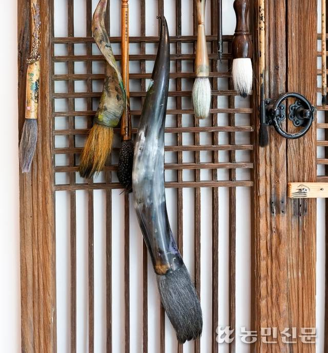 김 작가의 작업실 ‘글씨당’의 벽에 붓들이 걸려 있다.