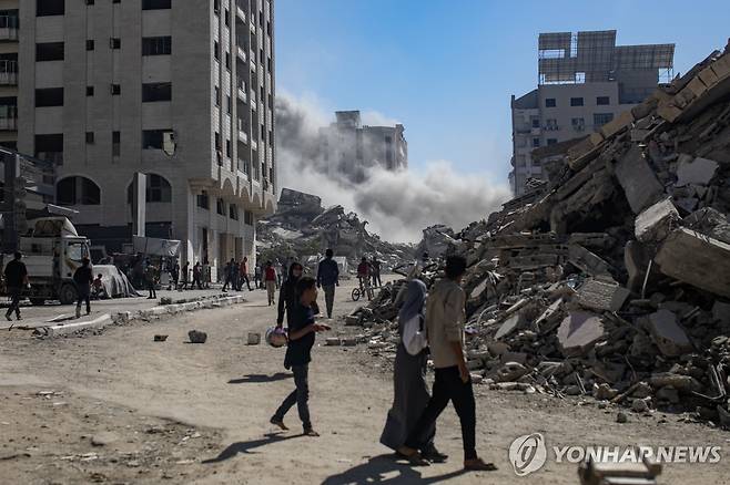 가자지구 (가자시티=EPA 연합뉴스) 13일(현지시간) 가자시티 주민들이 이스라엘군에 폭격 당한 건물에서 먼지가 피어오르는 것을 바라보고 있다. 2025.9.14 photo@yna.co.kr