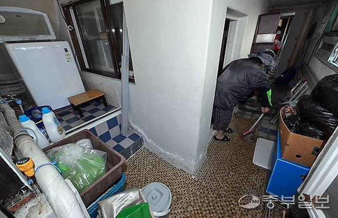 고령층들이 금전적 부담으로 반지하와 쪽방촌 등 취약한 주거환경으로 내몰리고 있는 가운데 15일 오전 수원시 권선구 소재 반지하촌에서 주민이 비로 인해 고여 있는 물을 빼내고 있다. 임채운기자