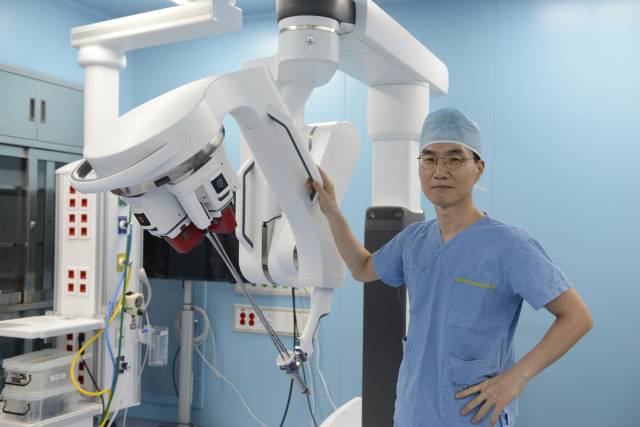 다빈치 SP 모델 앞에서 포즈를 취하고 있는 박정우 로봇수술센터장. 동아대병원 제공