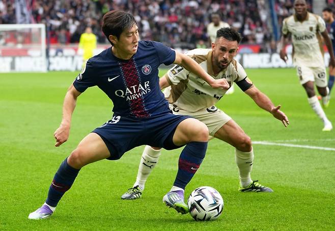 파리 생제르맹(PSG)의 이강인(왼쪽)이 15일 프랑스 파리 파르크 데 프랭스에서 열린 랑스와의 안방 경기(2-0·PSG 승)에서 아드리앵 토마손과 볼 경합을 벌이고 있다. 파리=AP 뉴시스