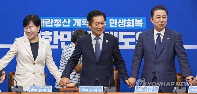 정청래(가운데) 더불어민주당 대표와 김병기 원내대표를 비롯한 최고위원들이 15일 국회에서 열린 최고위원회의에 입장해 서로 손을 잡고 있다. [연합뉴스]