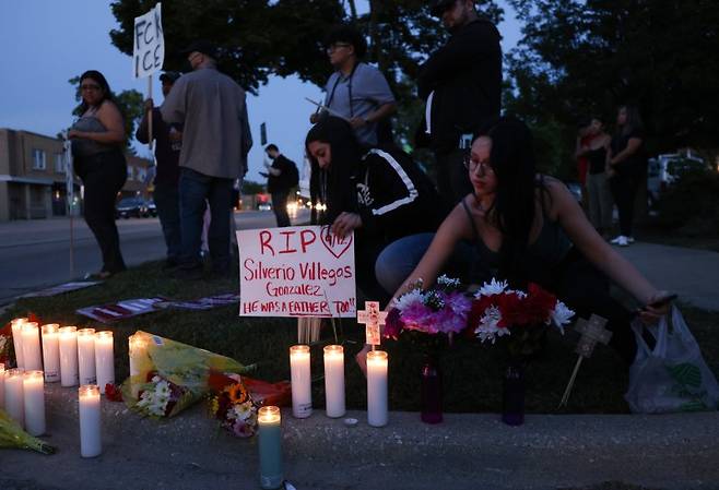 12일(현지시간) 미국 일리노이주 시카고의 반 ICE 시위에서 사람들이 ICE 요원의 총에 맞아 사망한 실버리오 비예가스 곤잘레스를 추모하기 위해 촛불을 켜고 있다.EPA연합뉴스