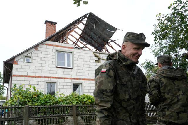 11일 폴란드 루블린 인근 비리키에서 러시아 드론의 영공 침범으로 파손된 주택을 군인들이 지켜보고 있다. AP 연합뉴스