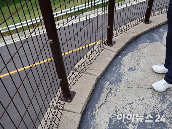 고정됐던 A씨 사업장의 펜스 주변 바닥이 균열로 인해 흔들리고 있다. [사진=장예린 기자]