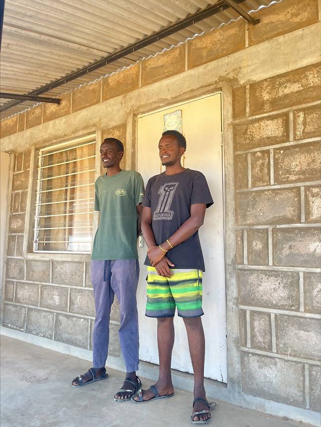 나자로 메르키찬과 로아 갈보란이 케냐 마르사빗주에 위치한 기아대책 코어사업장 앞에 서있다.