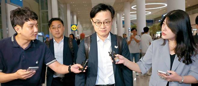 미국과 관세협상 후속 협의를 위해 지난주 급거 방미한 뒤 14일 새벽 인천국제공항에 도착한 김정관 산업통상자원부 장관이 협상 성과를 묻는 기자들의 질의에 굳게 입을 닫고 걸어가고 있다. 연합뉴스