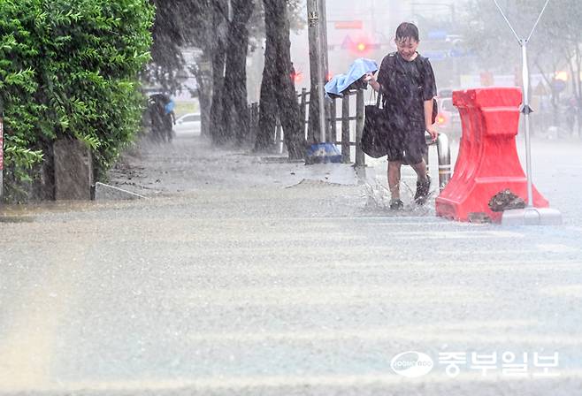 갑작스러운 소나기가 내린 16일 오후 용인시실내체육관 인근 거리에서 한 어린이가 고장난 우산을 들고 발걸음을 재촉하고 있다. 임채운기자