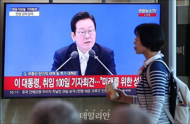 지난 11일 오전 서울 용산구 서울역에서 시민들이 이재명 대통령 취임 100일 기자회견을 시청하고 있다.ⓒ데일리안 홍금표 기자