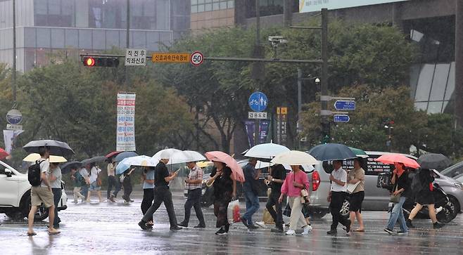 요란한 비가 내린 16일 오후 서울 종로구 광화문광장 인근을 지나는 시민들이 우산을 쓰고 발걸음을 옮기고 있다. 2025.9.16 뉴스1