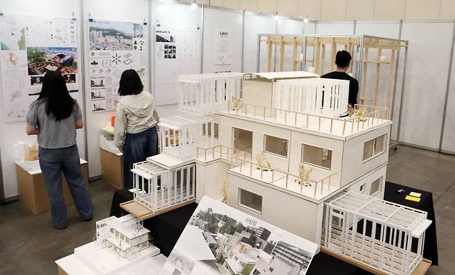 수상작 감상에 푹 '2025 부산국제건축제'가 개막한 17일 부산 해운대구 벡스코 제1전시장에서 관람객들이 올해 부산학생건축파빌리온 공모전 수상작을 둘러보고 있다. 오는 21일까지 열리는 이번 행사에서는 OMA 특별전, 부산문화건축전, 부산의 젊은 건축가4(Next Architects 4), 머무름의 공간-스테이 건축전, 바다에서 본 도시 부산, 세계적 건축가 강연, 주제전 연계 강연·대담 등이 진행된다. 뉴시스