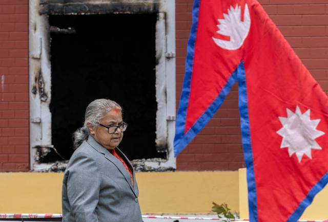네팔 반정부 시위 이후 취임한 수실라 카르키 과도정부 임시 총리가 15일 시위 과정에서 불탄 카트만두 대통령실 앞을 지나고 있다. 카트만두=EPA 연합뉴스