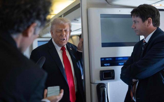 도널드 트럼프 미국 대통령이 16일 영국으로 향하기 위해 대통령 전용기 에어포스원에 탑승해 기자들과 이야기하고 있다. 워싱턴=AFP 연합뉴스