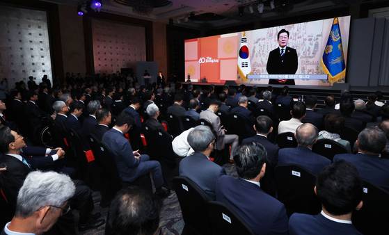 Attendees of the JoongAng Ilbo’s 60th anniversary ceremony watch President Lee Jae Myung’s congratulatory speech at Lotte Hotel in Jung District, central Seoul, on Sept. 17. [JANG JIN-YOUNG]
