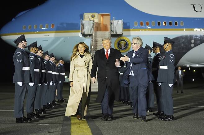 도널드 트럼프 대통령과 영부인 멜라니아 여사가 16일(현지시간) 런던 근교 스탠스테드 공항에 도착하자, 대기 경호관인 엔리 후드 자작(사진 중앙 오른쪽)이 맞이하고 있다. [AP ]